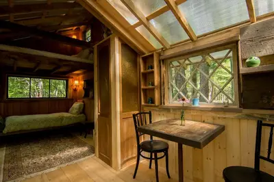 a room with a table and a window in a cabin at The Outlier Inn in Woodridge