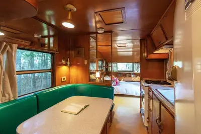 a kitchen with a green bench and a table at The Outlier Inn in Woodridge