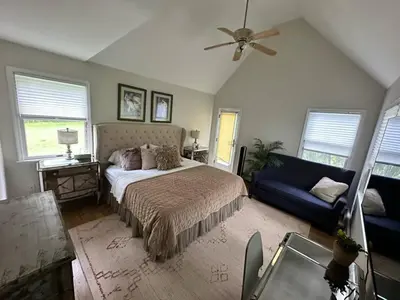 a bedroom with a bed and a blue couch at Beautiful Private Room Near Stony Brook University in Stony Brook