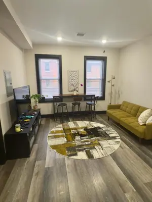 a living room with a couch and a table at Oasis de comodidad Habitación individual o compartida in Jersey City