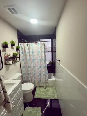 a bathroom with a toilet and a shower curtain at Oasis de comodidad Habitación individual o compartida in Jersey City