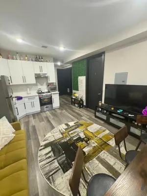 a large living room with a table and a kitchen at Oasis de comodidad Habitación individual o compartida in Jersey City