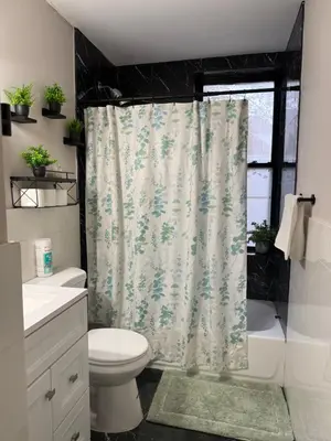 a bathroom with a shower curtain and a toilet at Oasis de comodidad Habitación individual o compartida in Jersey City