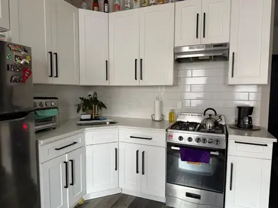 a kitchen with white cabinets and a stove top oven at Oasis de comodidad Habitación individual o compartida in Jersey City