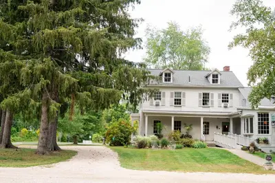 a white plantation house with a large tree at ButtonBall Inn in South Egremont
