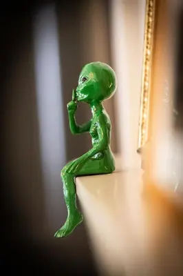 a green figurine of a person sitting on a table at ButtonBall Inn in South Egremont