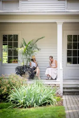 two women sitting on the porch of a house at ButtonBall Inn in South Egremont