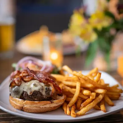 a white plate with a cheeseburger and french fries at ButtonBall Inn in South Egremont