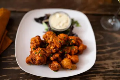 a plate of food with tater tots and sauce at ButtonBall Inn in South Egremont
