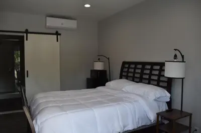 a bedroom with a bed with white sheets and a window at Tannersville Village Room 1 in Tannersville