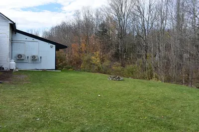 a yard with a white house and a field of grass at Tannersville Village Room 1 in Tannersville
