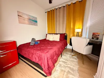a bedroom with a red bed and a chair at BP STAYS - Hotel-Style, No Host, Professionally Managed ID247 in Jersey City