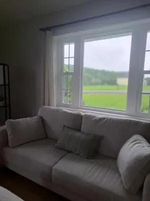 a white couch sitting in front of a window at Cozy Country Cottage in Norwich