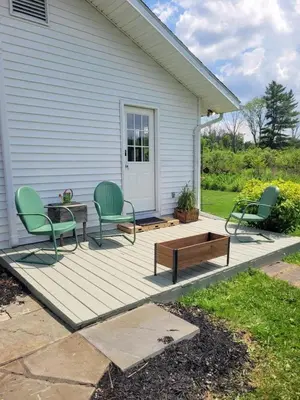a deck with two chairs and a table and a bench at Cozy Country Cottage in Norwich