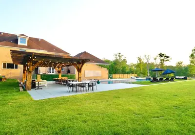 a patio with tables and umbrellas in a yard at Carpathia West Estate in West Milford