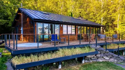 a cabin in the woods with a large deck at Modern Catskills Escape w Open Living Steam Shower Hot Tub w Mountain Views Minutes from Woodstock Trails Suncliff Vista in Shokan