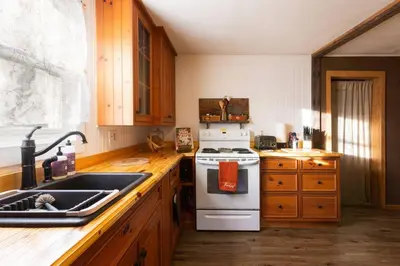 a kitchen with a white stove and a sink at Cozy Cabin Style Apt Private 1st Flr 1 Bdrm in Torrington