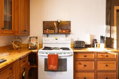 a kitchen with a white stove and wooden cabinets at Cozy Cabin Style Apt Private 1st Flr 1 Bdrm in Torrington