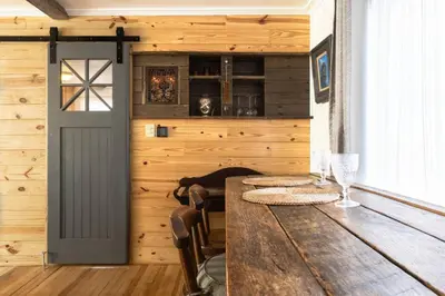 a dining room with a wooden table and a door at Cozy Cabin Style Apt Private 1st Flr 1 Bdrm in Torrington