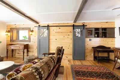 a living room with a couch and a wooden wall at Cozy Cabin Style Apt Private 1st Flr 1 Bdrm in Torrington
