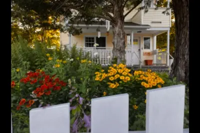 a garden of flowers in front of a house at Cozy Cabin Style Apt Private 1st Flr 1 Bdrm in Torrington