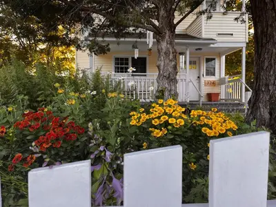 a garden of flowers in front of a house at Cozy Cabin Style Apt Private 1st Flr 1 Bdrm in Torrington