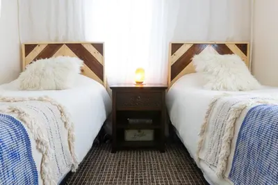 two beds with white pillows on them in a room at Private Classy 2nd Flr 3 Bed Apt Near Downtown in Torrington