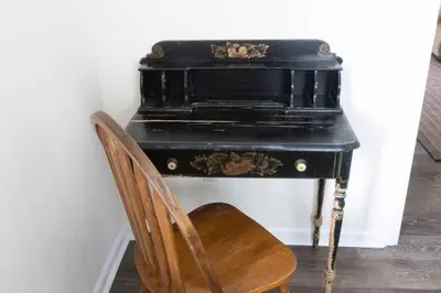 a black desk with a wooden chair next to it at Private Classy 2nd Flr 3 Bed Apt Near Downtown in Torrington