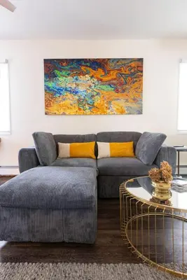a living room with a couch and a painting at Private Modern 1st Flr 3 Bed Apt Close to Downtown in Torrington