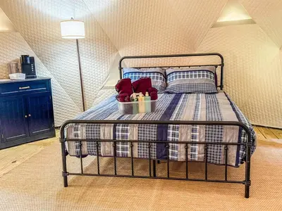 a bed with a basket with red shoes on it at Cozy Mountain Dome Escape in the Catskills in Gilboa