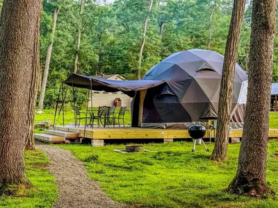 a tent in the middle of a field with trees at Luxury Catskill Mountains Dome Retreat in Gilboa