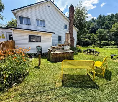 a yard with a yellow chair and a house at Luxury Catskill Mountains Dome Retreat in Gilboa