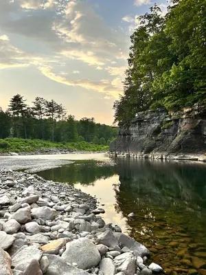 a river with rocks and trees on the shore at Luxury Catskill Mountains Dome Retreat in Gilboa