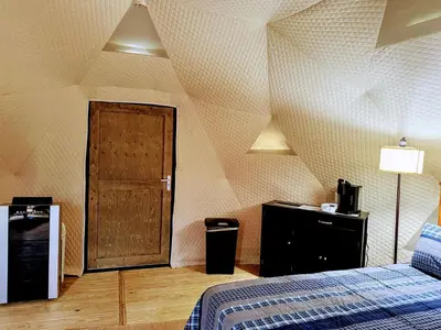 a room with a bed and a wooden door at Luxury Catskill Mountains Dome Retreat in Gilboa