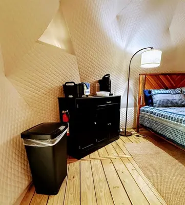 a bedroom with a trash can next to a bed at Luxury Catskill Mountains Dome Retreat in Gilboa