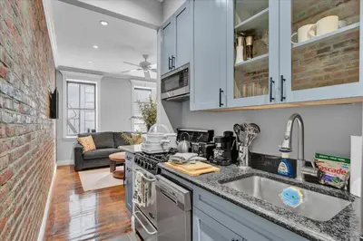 a kitchen with a sink and a stove top oven at Stylish 3BR-2BA in Gramercy -Modern & Central in New York