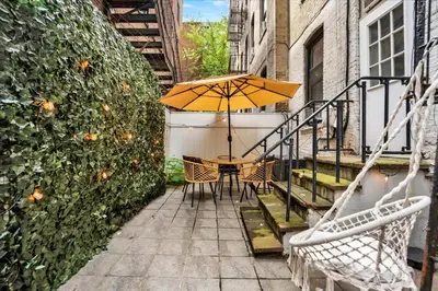 a table with an umbrella on a patio at Modern 2BR with Private Garden In Gramercy Park in New York
