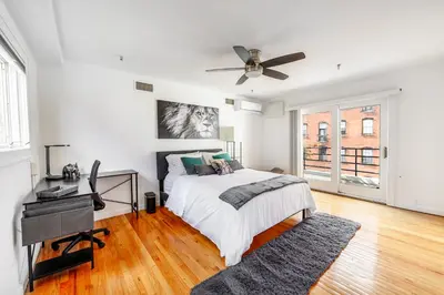 a white bedroom with a bed and a ceiling fan at Modern 3BR Townhouse with Private Rooftop & Parking Minutes to NYC in Hoboken