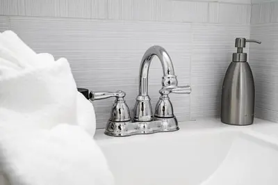 a kitchen sink with a faucet and a bottle of soap at Modern 3BR Townhouse with Private Rooftop & Parking Minutes to NYC in Hoboken