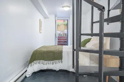 a bedroom with a bunk bed and a ladder at Charming Upper East Side W Outdoor Space in New York