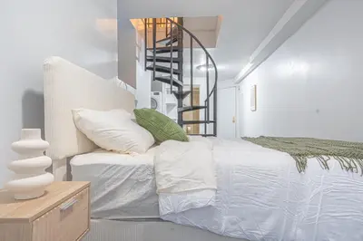 a bedroom with a bed and a spiral staircase at Charming Upper East Side W Outdoor Space in New York