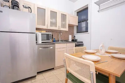 a kitchen with a wooden table and a refrigerator at Charming Upper East Side W Outdoor Space in New York