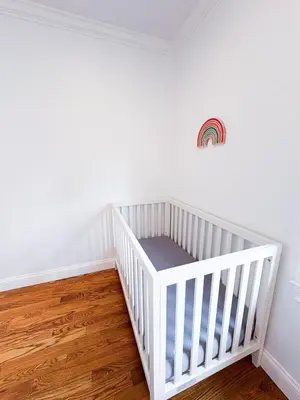a white crib in a room with a wooden floor at Family-Friendly 4 Bed 3 Bath Downtown Delight in Stamford