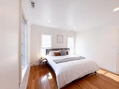 a white bedroom with a large bed and windows at Family-Friendly 4 Bed 3 Bath Downtown Delight in Stamford