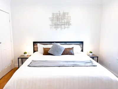 a bedroom with a large white bed with two tables at Family-Friendly 4 Bed 3 Bath Downtown Delight in Stamford