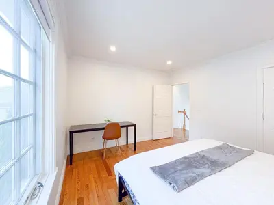 a bedroom with a bed and a desk and a window at Family-Friendly 4 Bed 3 Bath Downtown Delight in Stamford