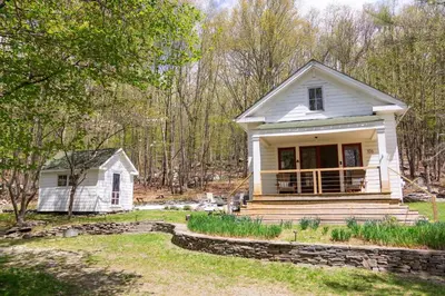 a small white house in the woods at Fire Pit, Private & Stylish Birdsong Schoolhouse in Barryville