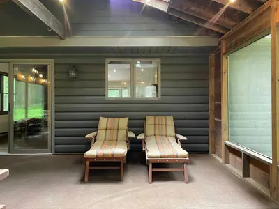 two chairs and a table on a patio at Fire Pit Woodsy & Private - Cabin on Woods Road in Yulan