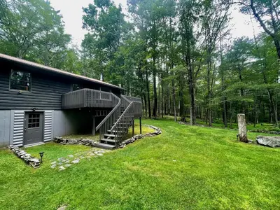 a house with a spiral staircase next to a yard at Fire Pit Woodsy & Private - Cabin on Woods Road in Yulan