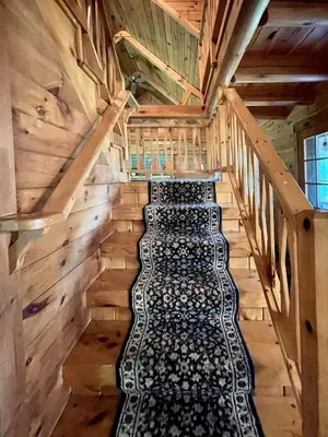 a staircase in a log cabin with wine bottles at Fire Pit, BBQ & Sprawling Lawn Elk Point Cabin in Livingston Manor